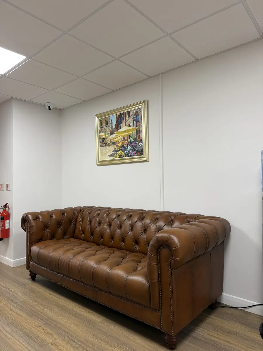 The waiting area with a leather chesterfield sofa