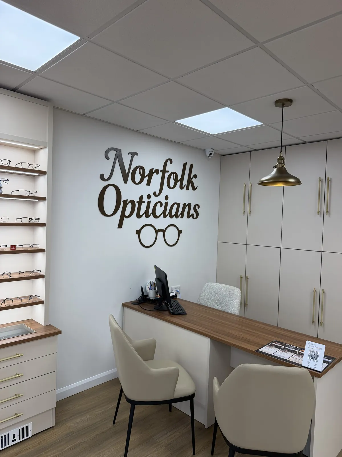 Norfolk Opticians lettering above the consultation desk in our refitted Ashby practice